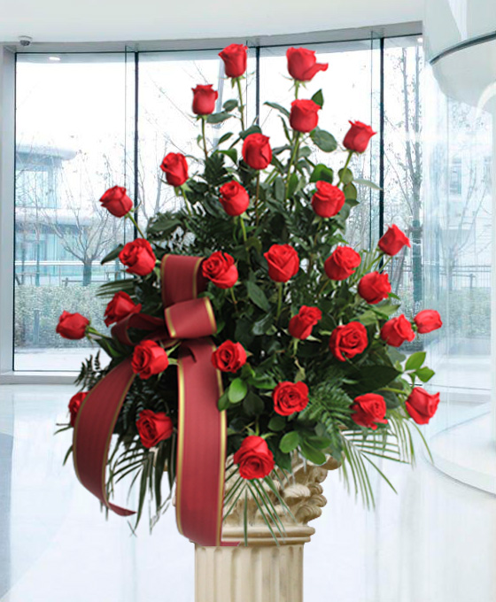Centro de 30 rosas rojas con verdes variados y cinta funeraria roja