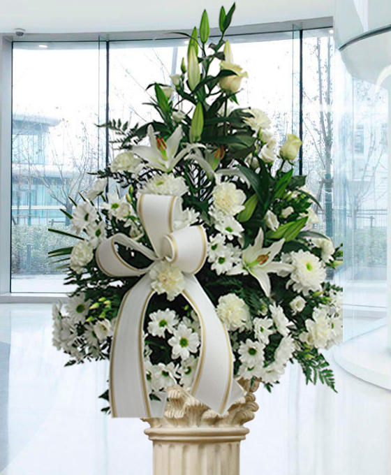 Centro de flores de claveles, liliums, lisianthus, margaritas y rosas blancas con y cinta blanca
