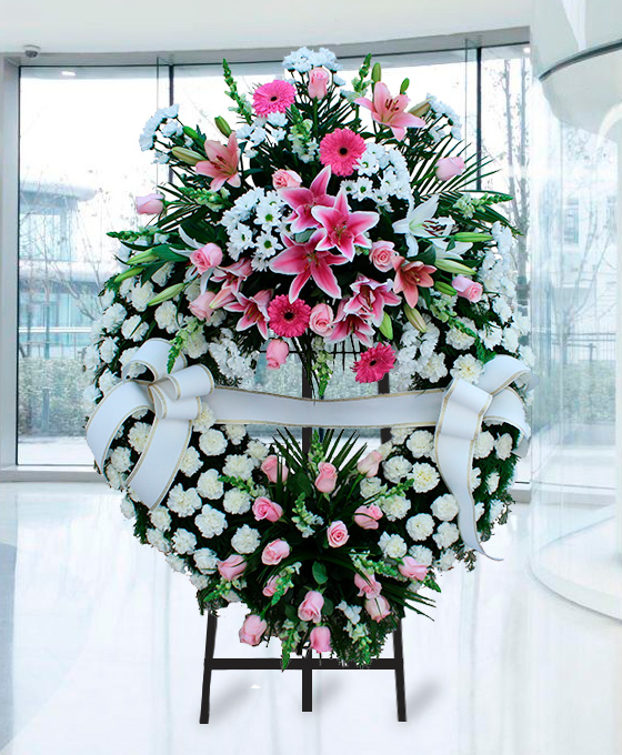 Corona funeraria con flores blancas y rosas con dos cabezales
