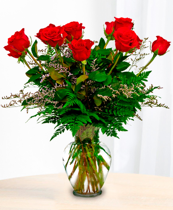 Ramo de 10 rosas rojas con hojas y verdes variados en un jarrón de cristal