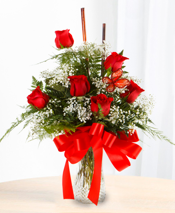 Ramo de 6 rosas rojas con paniculata en un jarrón de cristal y una cinta roja